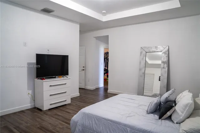 a bedroom with a bed and flat screen tv