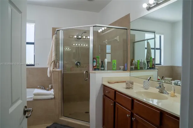 a bathroom with a shower sink and mirror