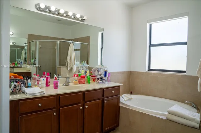 a bathroom with a sink mirror vanity and bathtub