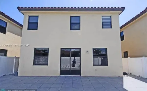 a front view of a house with a garden and trees