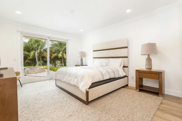 a bed sitting in a spacious bedroom next to a window