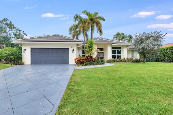 a front view of house with yard and green space