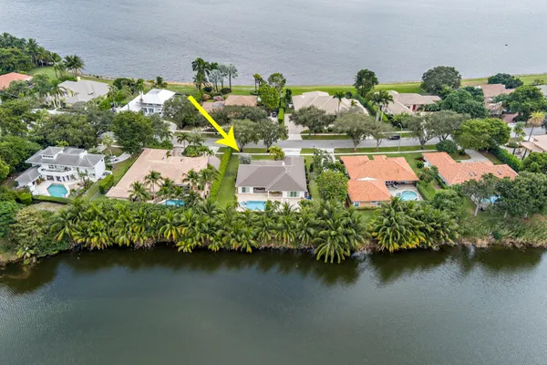 an aerial view of a house with a garden and lake view