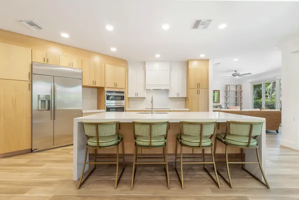 a kitchen with kitchen island granite countertop wooden cabinets and chairs
