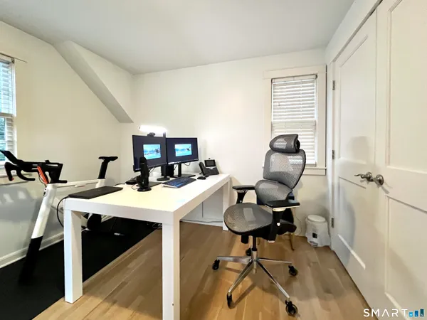 a view of a workspace with furniture and a window