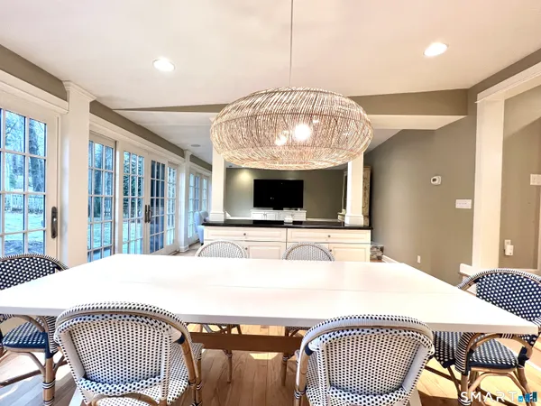 a living room with a table chairs and a chandelier