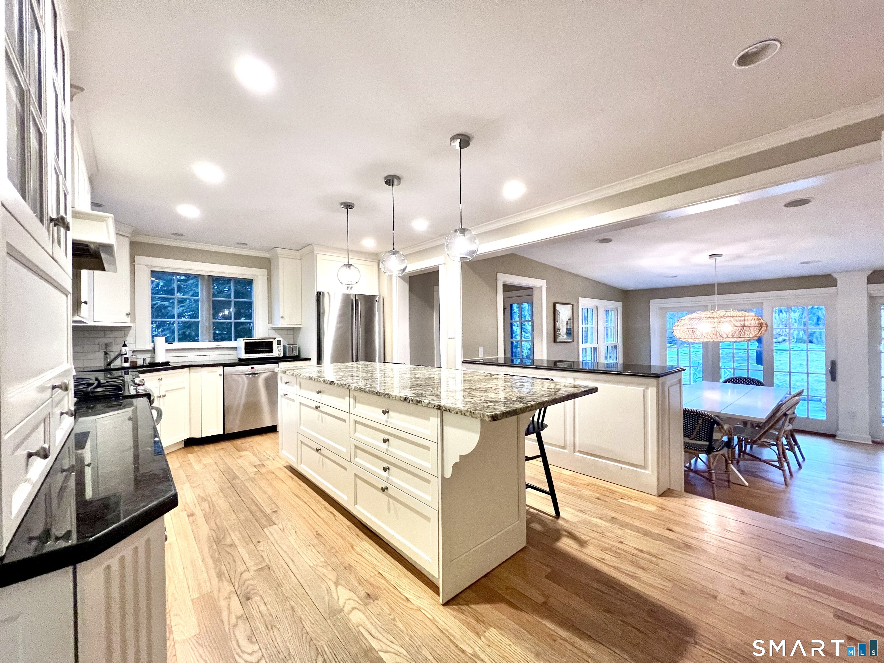 14 Laforge Road Darien, CT 06820 - Photo 5 of 35 a large kitchen with stainless steel appliances kitchen island granite countertop a large stove a sink a dining table and chairs with wooden floor