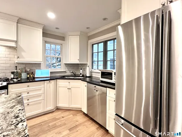 a kitchen with stainless steel appliances granite countertop a refrigerator sink and cabinets