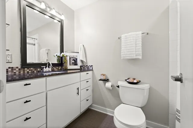 a bathroom with a toilet sink and mirror