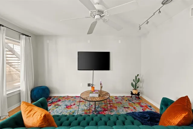 a living room with furniture a flat screen tv and a window