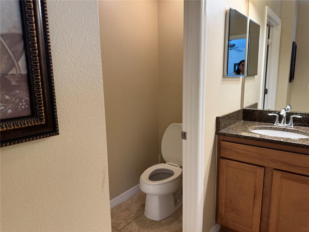 8975 Candy Palm Road Kissimmee, FL 34747 - Photo 15 of 27 a bathroom with a granite countertop toilet sink and mirror
