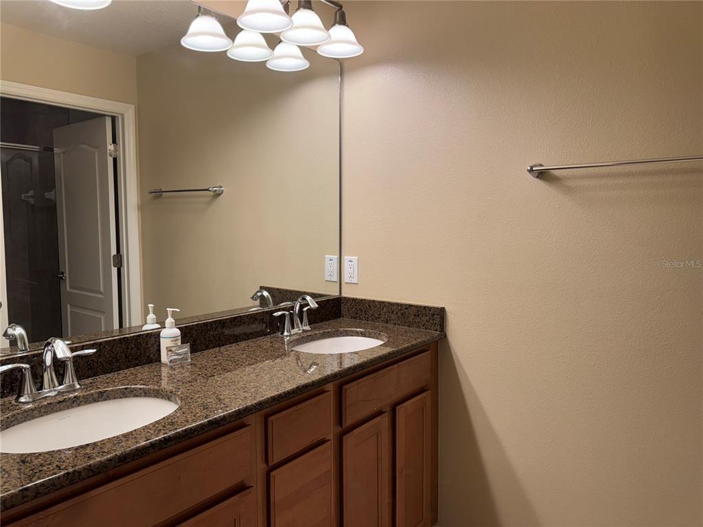 8975 Candy Palm Road Kissimmee, FL 34747 - Photo 18 of 27 a bathroom with a granite countertop sink and a mirror