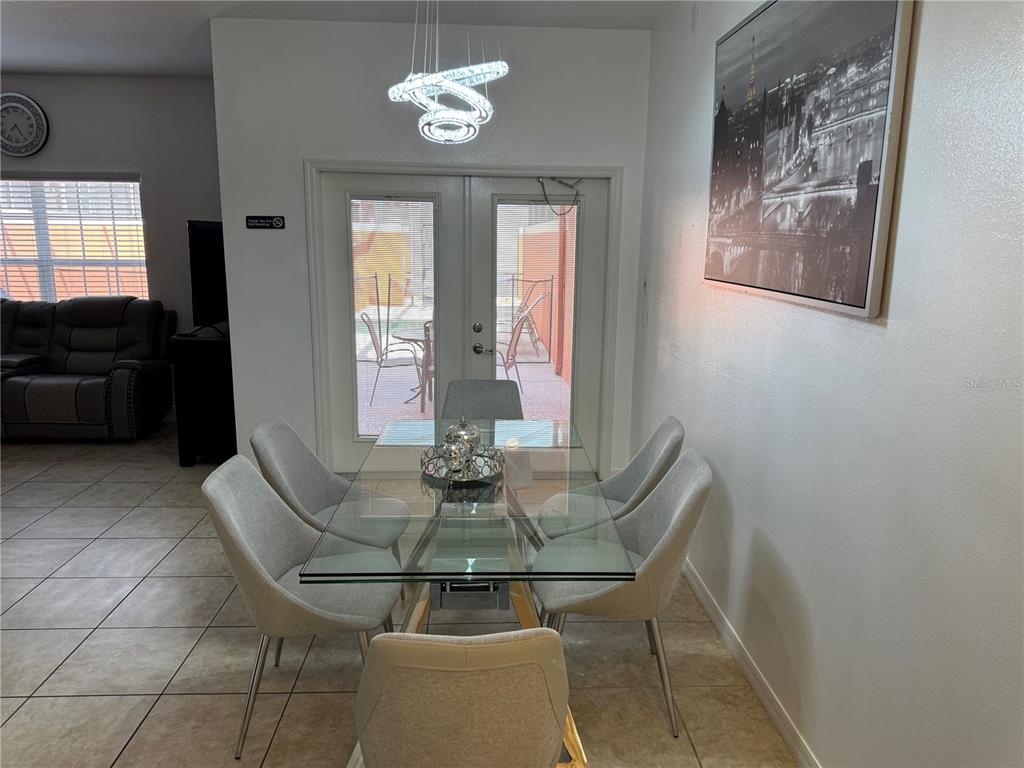 8975 Candy Palm Road Kissimmee, FL 34747 - Photo 3 of 27 a view of a dining room with furniture and chandelier