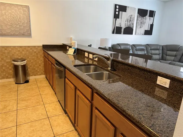 a kitchen with granite countertop a sink and a wooden floor