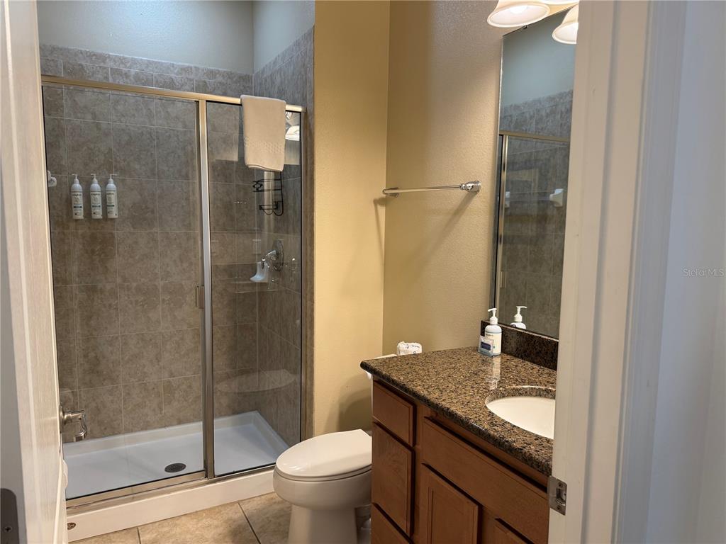 8975 Candy Palm Road Kissimmee, FL 34747 - Photo 10 of 27 a bathroom with a granite countertop shower a toilet and a sink