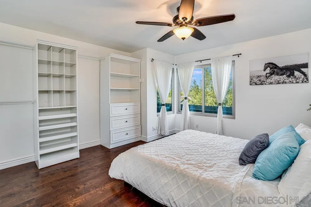 749 Nob Circle Vista, CA 92084 - Photo 12 of 23 a bedroom with a bed chandelier and a window