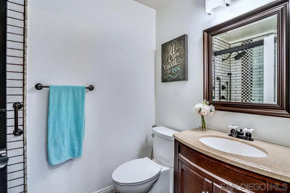749 Nob Circle Vista, CA 92084 - Photo 14 of 23 a bathroom with a granite countertop toilet sink and mirror