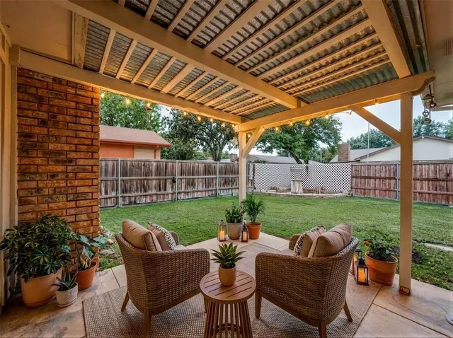 a backyard of a house with a table and chairs