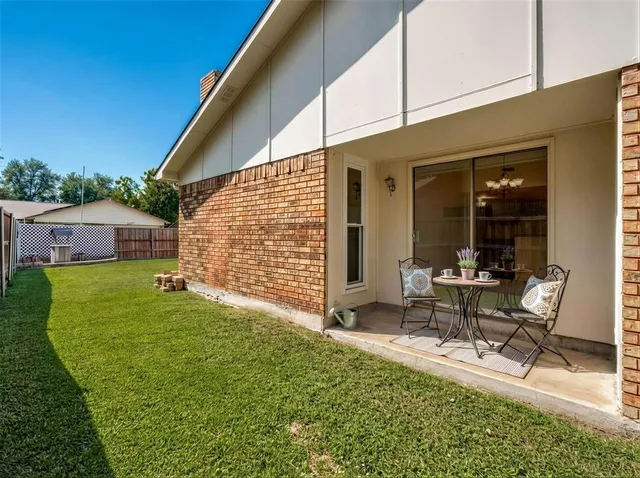 a backyard of a house with table and chairs