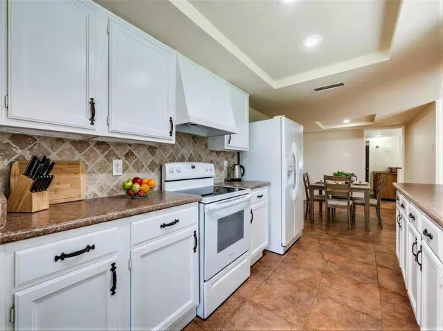 a kitchen with white cabinets and white appliances