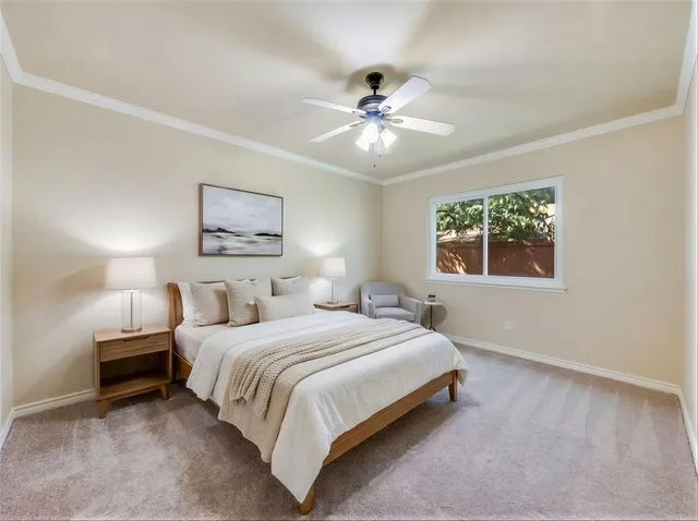 a bedroom with a large bed and a ceiling fan