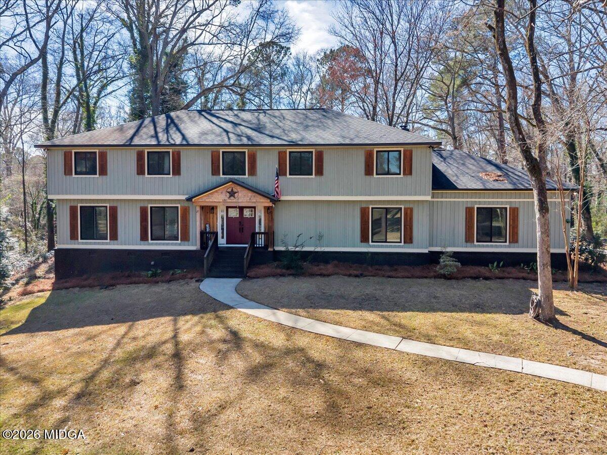 a front view of a house with a yard covered in snow