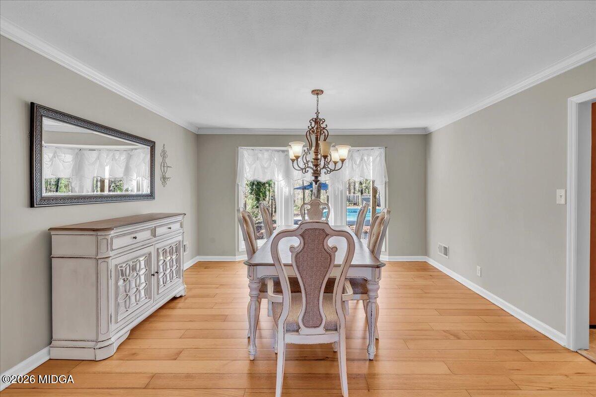 5256 Rivoli Drive Macon, GA 31210 - Photo 13 of 91 a view of a dining room with furniture a chandelier and wooden floor