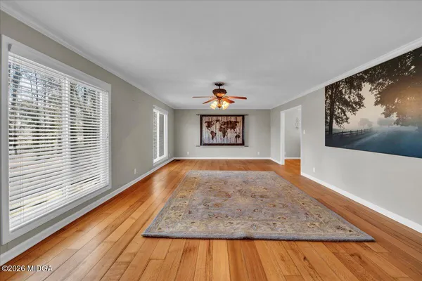 a view of a dining room with furniture a chandelier and wooden floor