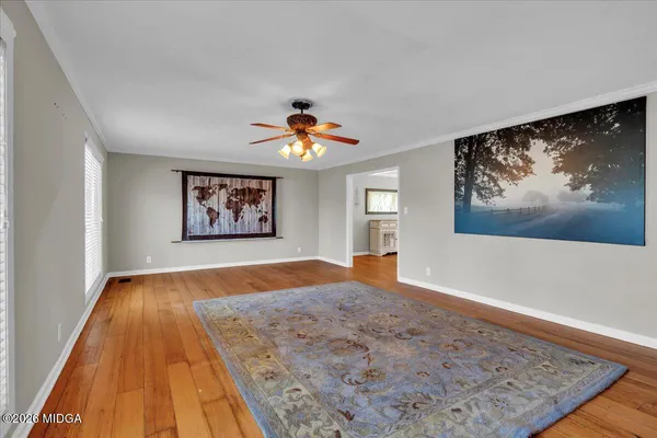 a view of a dining room with furniture a chandelier and wooden floor