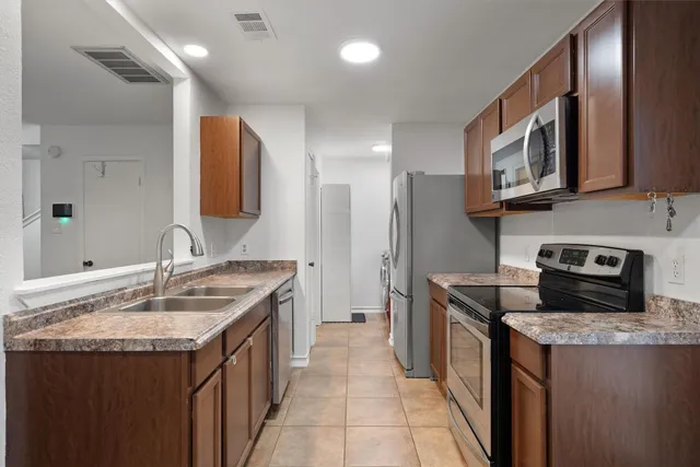 a kitchen with stainless steel appliances granite countertop a sink stove and refrigerator