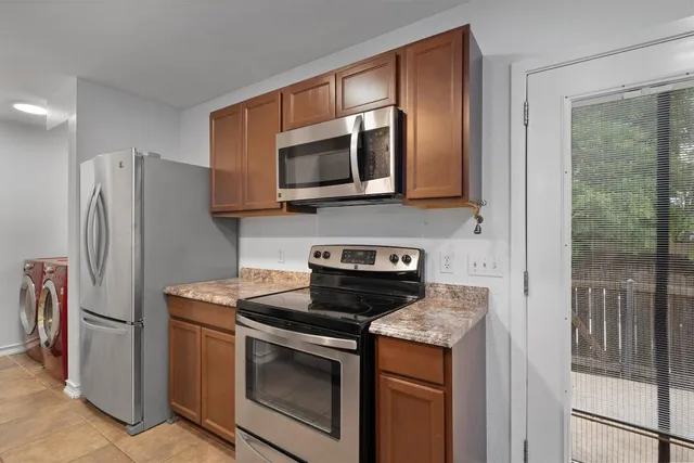 a kitchen with stainless steel appliances granite countertop a stove a refrigerator and a microwave