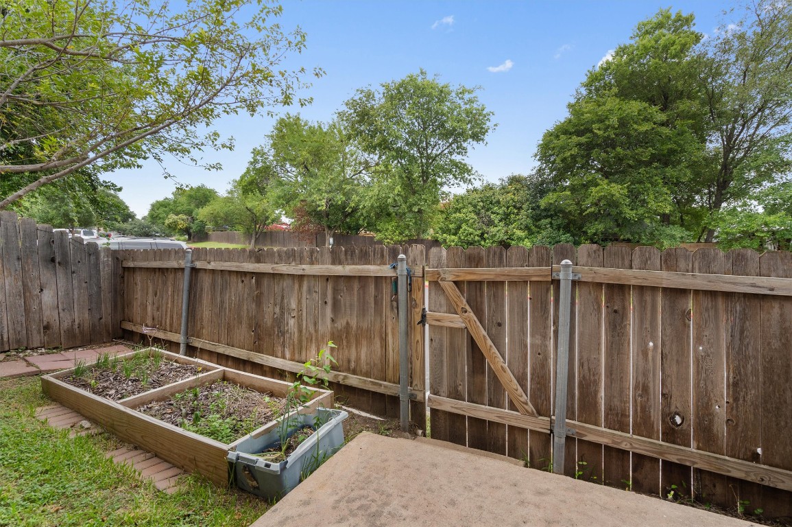 1015 East Yager Lane, Unit 129 Austin, TX 78753 - Photo 31 of 39 a view of a backyard with wooden fence and a large tree