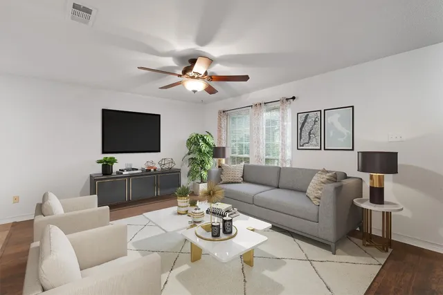 a living room with furniture a dining table and a flat screen tv