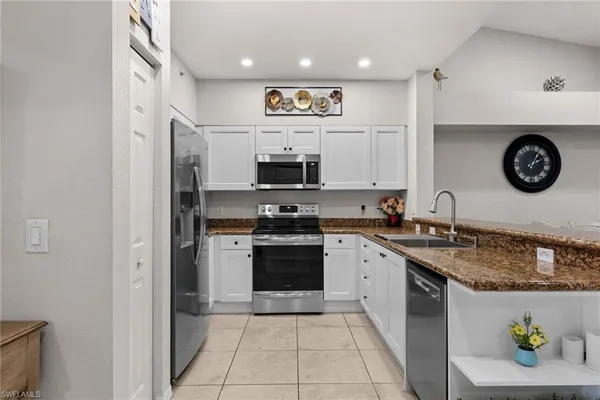a kitchen with stainless steel appliances granite countertop a stove a sink and a microwave