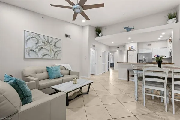 a living room with furniture a dining table and kitchen view