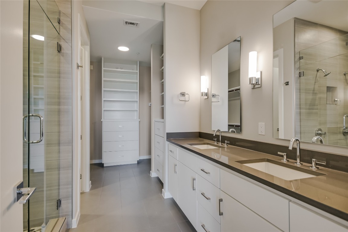 5921 Hiline Road, Unit 2403 Austin, TX 78734 - Photo 17 of 35 a bathroom with a granite countertop double vanity sink mirror and shower