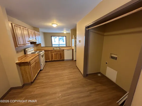 a kitchen with a sink a refrigerator a window and cabinets