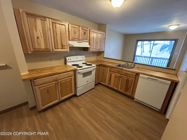 a kitchen with granite countertop white cabinets and white appliances