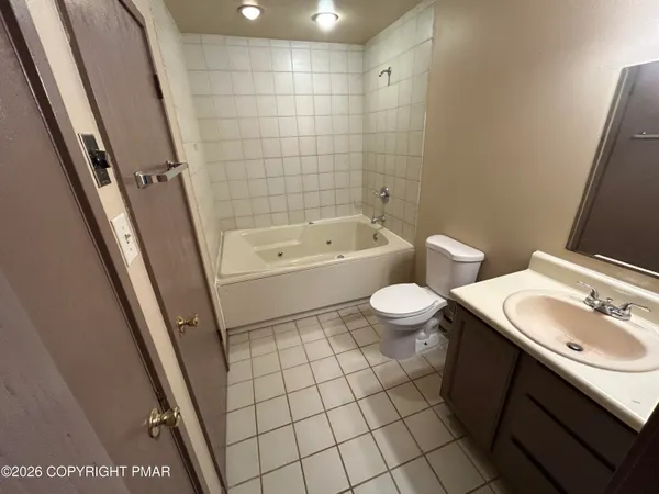 a bathroom with a sink a toilet a mirror and shower