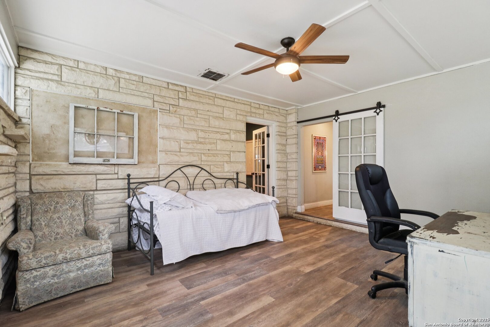 503 Mockingbird Lane Devine, TX 78016 - Photo 12 of 49 a bedroom with a bed and a chandelier