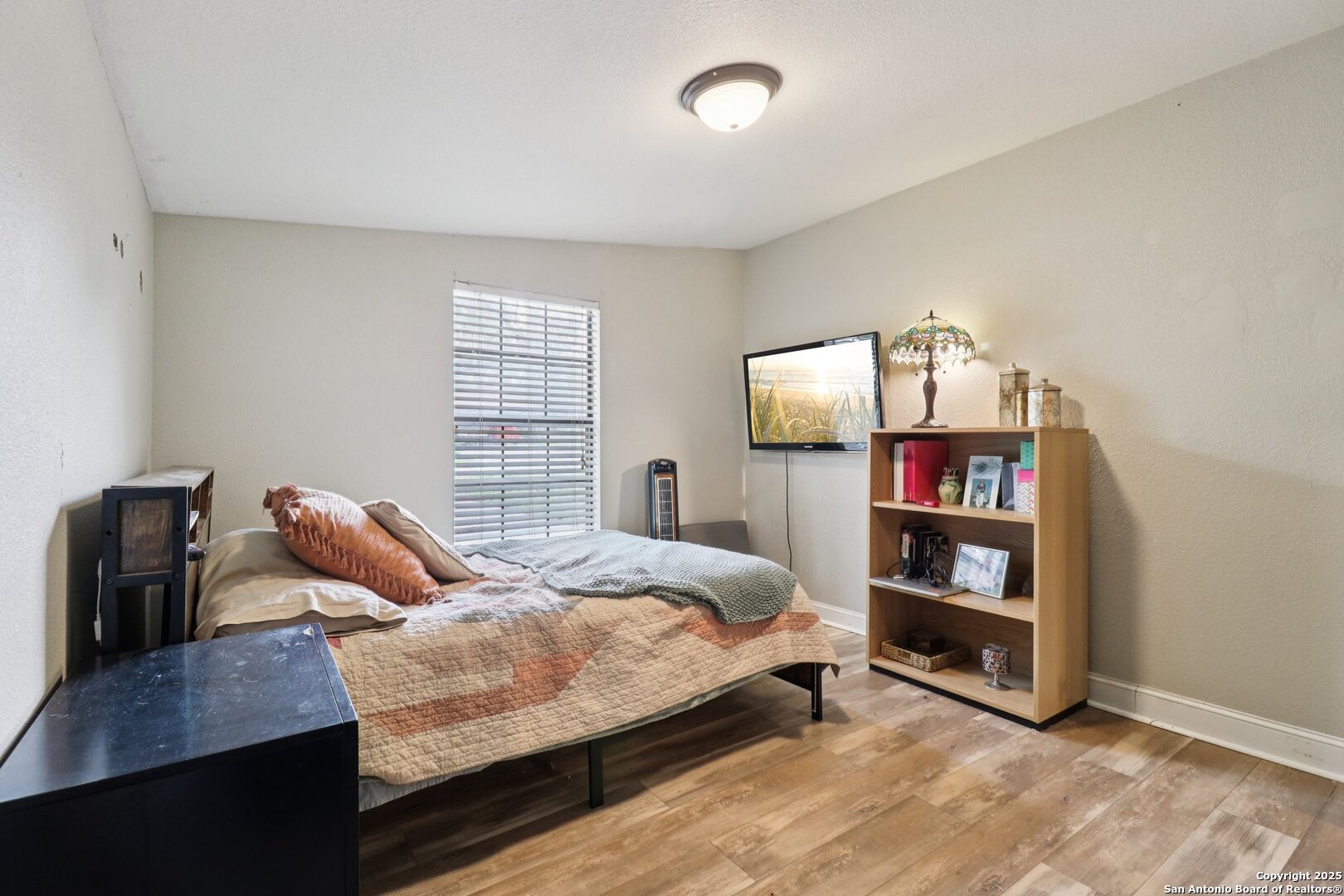 503 Mockingbird Lane Devine, TX 78016 - Photo 23 of 49 a bedroom with a bed and a bookshelf