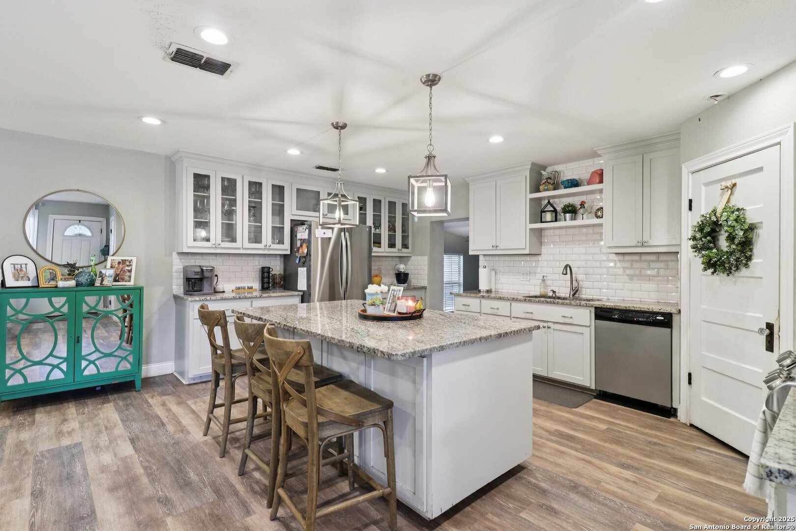 503 Mockingbird Lane Devine, TX 78016 - Photo 7 of 49 a kitchen with stainless steel appliances kitchen island granite countertop a table chairs and a refrigerator