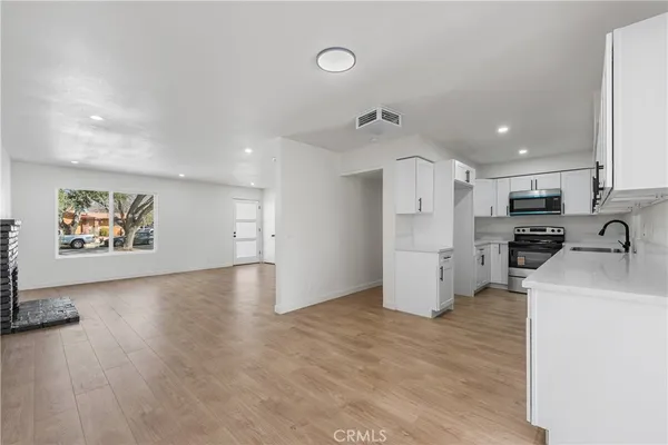 a view of a kitchen with furniture and wooden floor