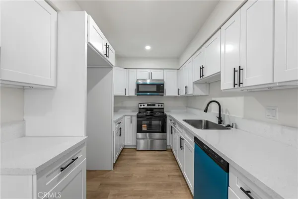 a kitchen with stainless steel appliances granite countertop a sink stove and cabinets