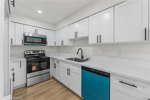 a kitchen with stainless steel appliances granite countertop a sink stove and microwave