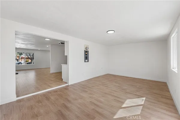 a view of a big room with wooden floor and windows