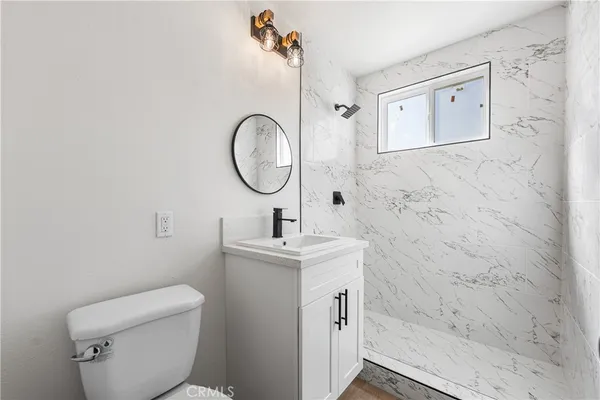 a bathroom with a toilet sink vanity and mirror