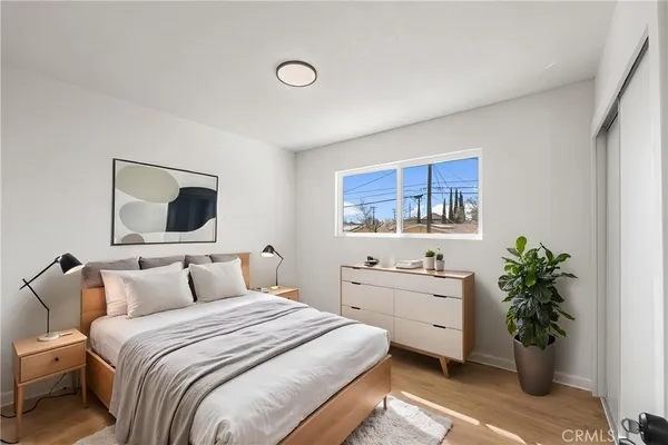 a bedroom with a bed and a potted plant
