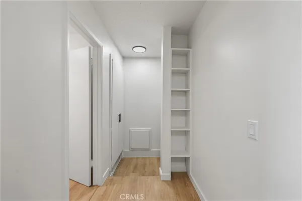 a view of a hallway with wooden floor and closet