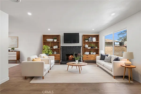 a living room with furniture a fireplace and a flat screen tv